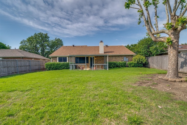 rear view of property featuring a chimney and brick siding