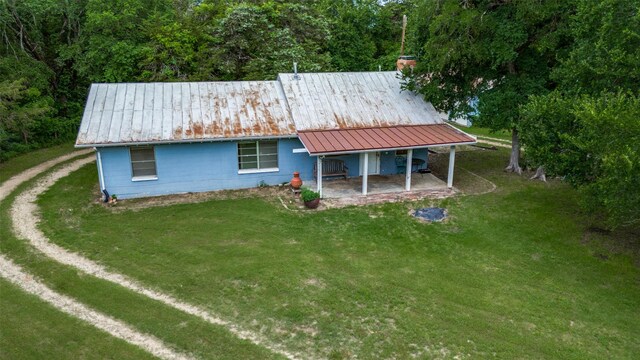1455 N Joe Wilson Rd, Cedar Hill, TX 75104 - rear view of house with a lawn, metal roof, driveway, and a wooded view