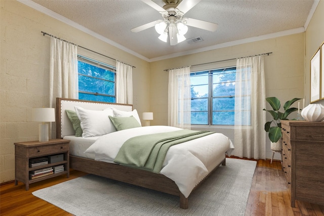 1455 N Joe Wilson Rd, Cedar Hill, TX 75104 - bedroom featuring hardwood / wood-style flooring, a textured ceiling, crown molding, a ceiling fan, and concrete block wall