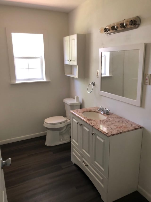 132 Keck St, Nocona, TX 76255 - half bath with wood finished floors, toilet, vanity, and baseboards