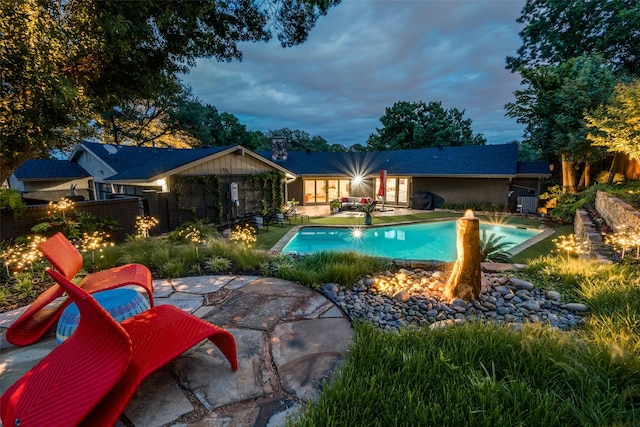 swimming pool with a patio area, fence, and an outdoor fire pit