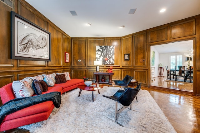 living room with a decorative wall and recessed lighting
