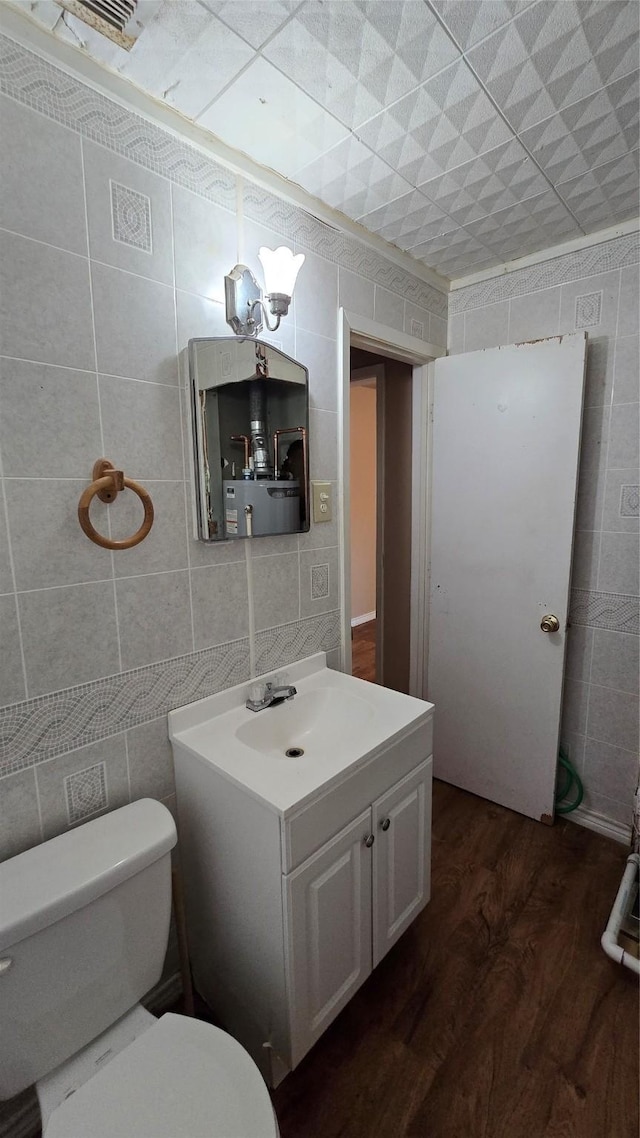 897 Sunset Dr, Abilene, TX 79605 - half bath with tile walls, wood finished floors, vanity, and toilet