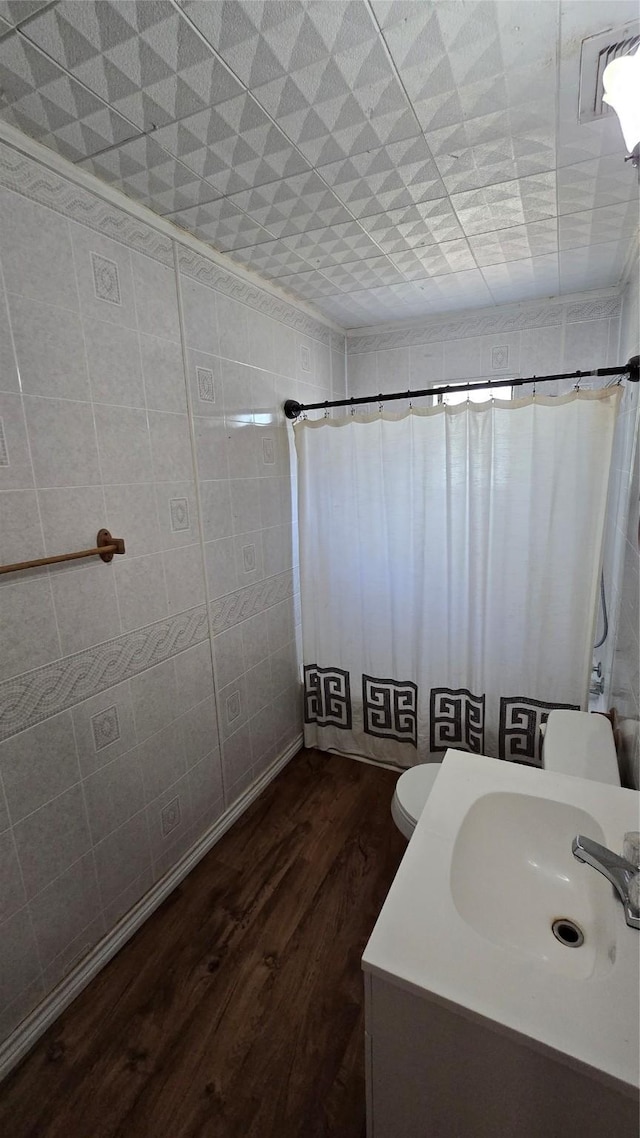 897 Sunset Dr, Abilene, TX 79605 - full bathroom featuring wood finished floors, vanity, toilet, and curtained shower