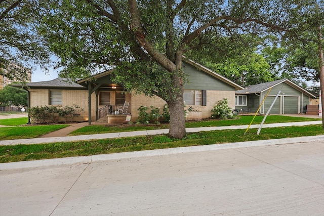 view of front of property featuring brick siding, an attached garage, a front yard, and concrete driveway