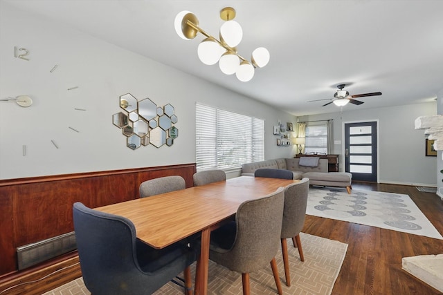 dining area with wood finished floors, ceiling fan, and a chandelier