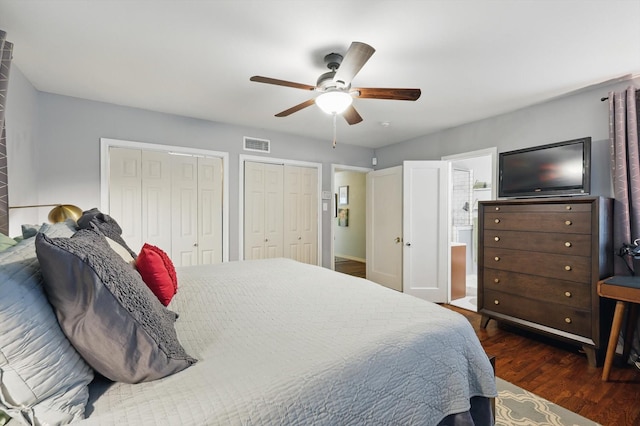 bedroom with wood finished floors, multiple closets, a ceiling fan, and ensuite bathroom