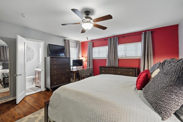 bedroom featuring wood finished floors, ceiling fan, ensuite bathroom, arched walkways, and baseboards