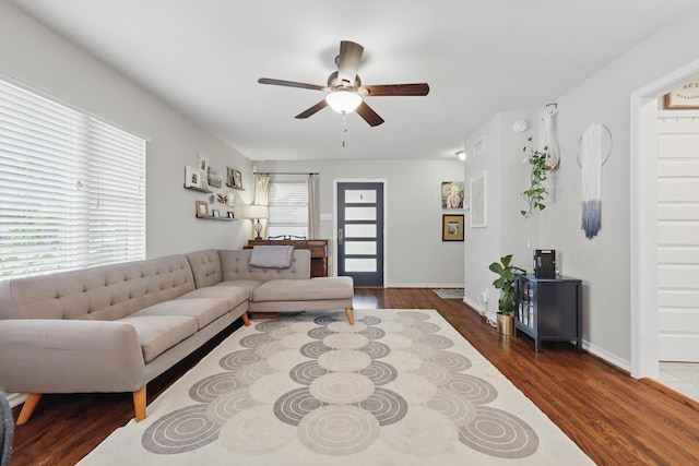 living room with a ceiling fan, dark wood-style floors, and baseboards