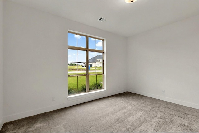 empty room featuring carpet floors and baseboards