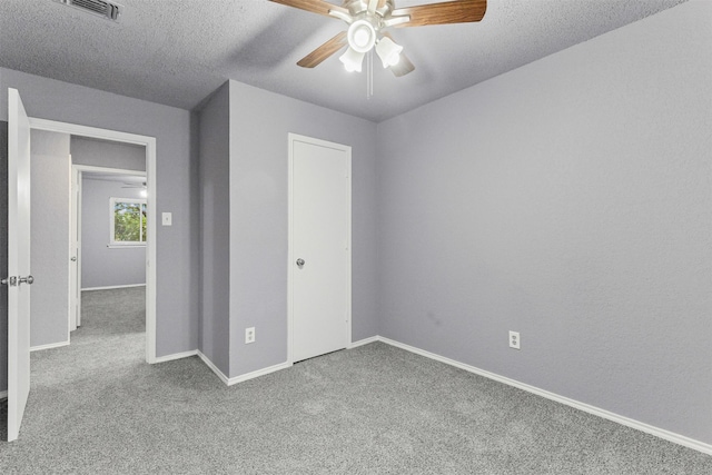 unfurnished bedroom featuring carpet floors, baseboards, ceiling fan, a closet, and a textured ceiling