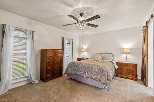 carpeted bedroom featuring crown molding, a barn door, baseboards, and ceiling fan