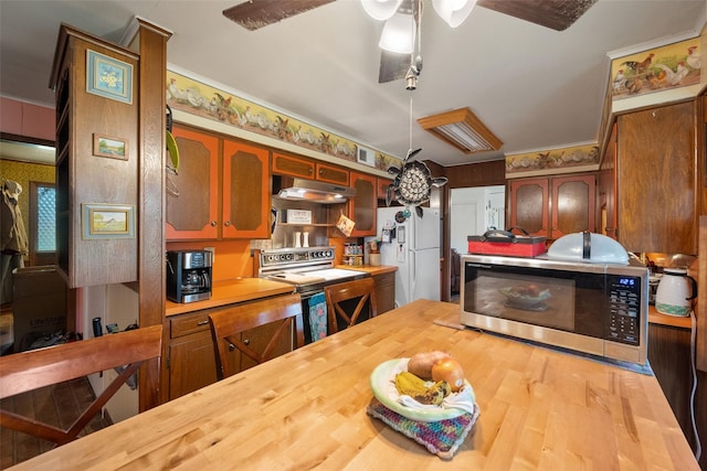 201 Sunset Dr, Fairfield, TX 75840 - kitchen with stainless steel microwave, freestanding refrigerator, butcher block counters, range with electric stovetop, and under cabinet range hood