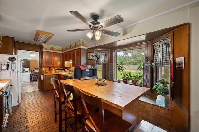 201 Sunset Dr, Fairfield, TX 75840 - dining area with a ceiling fan, brick floors, wooden walls, and ornamental molding