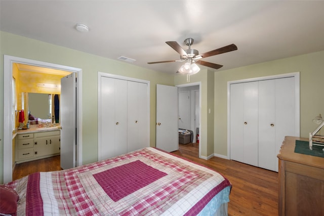 201 Sunset Dr, Fairfield, TX 75840 - bedroom featuring two closets, wood finished floors, ensuite bathroom, and a ceiling fan
