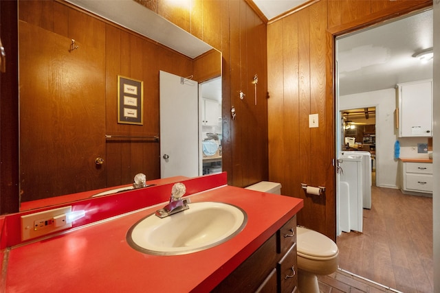 201 Sunset Dr, Fairfield, TX 75840 - bathroom featuring independent washer and dryer, toilet, wood walls, wood finished floors, and vanity