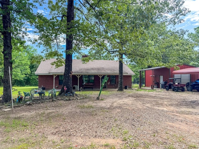 3836 Farm Road 196 N, Paris, TX 75462 - back of property featuring an outdoor structure, a pole building, brick siding, and a porch