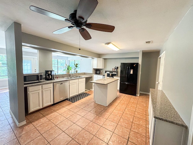 3836 Farm Road 196 N, Paris, TX 75462 - kitchen featuring stainless steel appliances, a sink, light tile patterned floors, a center island, and ceiling fan