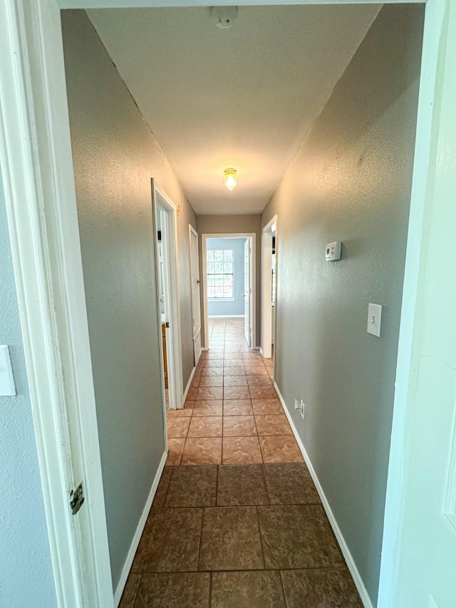3836 Farm Road 196 N, Paris, TX 75462 - corridor featuring baseboards, a textured wall, and stone finish floors