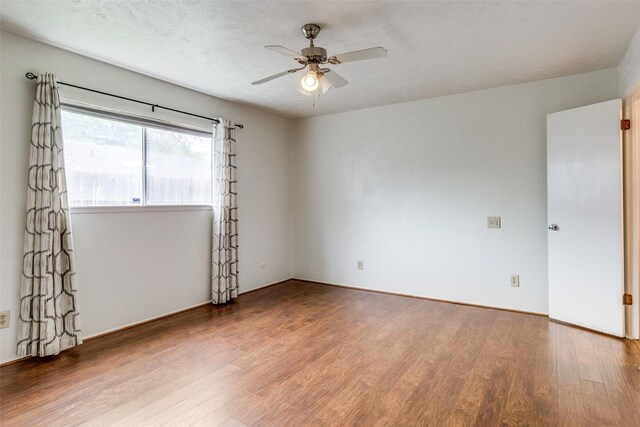 empty room with wood finished floors and a ceiling fan