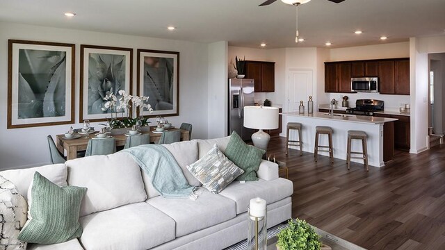 living room with dark wood-style flooring, a ceiling fan, and recessed lighting