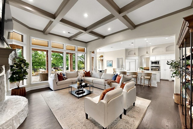 3001 Pecan Grove Ln, Celina, TX 75078 - living area featuring beamed ceiling, a fireplace, coffered ceiling, arched walkways, and dark wood-style floors