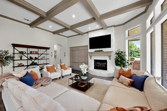 3001 Pecan Grove Ln, Celina, TX 75078 - living area featuring arched walkways, coffered ceiling, beam ceiling, and a fireplace