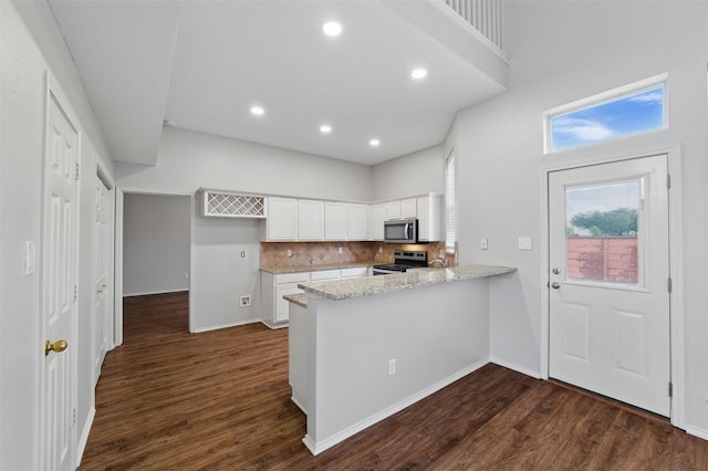 2763 Beverly Dr, Rockwall, TX 75032 - kitchen featuring appliances with stainless steel finishes, a peninsula, white cabinets, dark wood finished floors, and recessed lighting