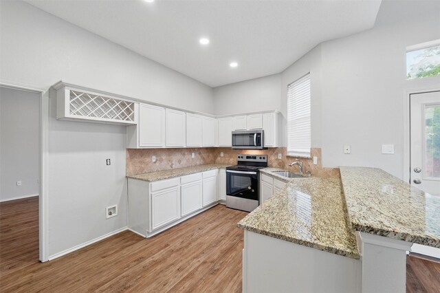 2763 Beverly Dr, Rockwall, TX 75032 - kitchen with appliances with stainless steel finishes, a peninsula, a sink, light wood-style floors, and light stone countertops