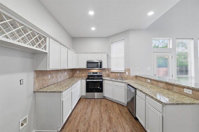 2763 Beverly Dr, Rockwall, TX 75032 - kitchen featuring stainless steel appliances, a sink, a peninsula, plenty of natural light, and recessed lighting