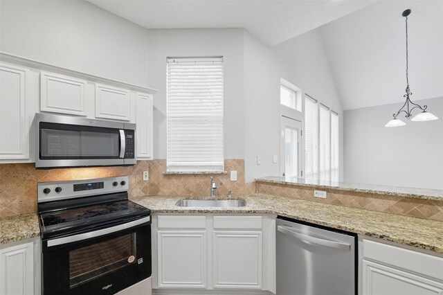 2763 Beverly Dr, Rockwall, TX 75032 - kitchen featuring appliances with stainless steel finishes, a sink, tasteful backsplash, white cabinetry, and light stone counters
