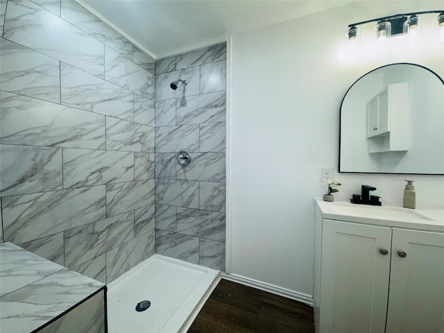 2719 S 27th, Waco, TX 76706 - full bathroom featuring wood finished floors, a tile shower, baseboards, and vanity