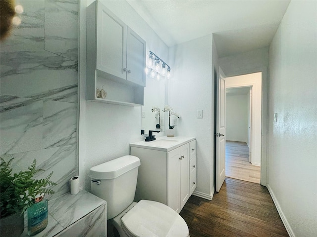 2719 S 27th, Waco, TX 76706 - bathroom featuring wood finished floors, baseboards, vanity, and toilet