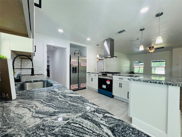 2719 S 27th, Waco, TX 76706 - kitchen with stainless steel appliances, island exhaust hood, a sink, a peninsula, and decorative backsplash