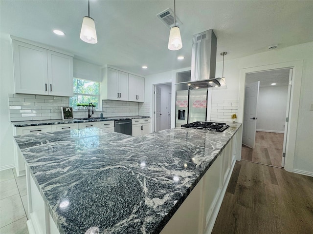 2719 S 27th, Waco, TX 76706 - kitchen with island range hood, appliances with stainless steel finishes, a sink, decorative backsplash, and white cabinetry