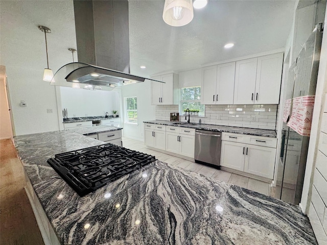 2719 S 27th, Waco, TX 76706 - kitchen with stainless steel dishwasher, island range hood, a sink, dark stone counters, and white cabinetry