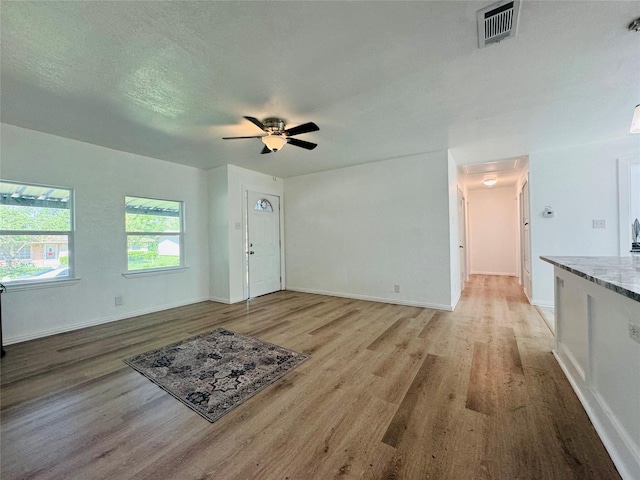 2719 S 27th, Waco, TX 76706 - unfurnished living room with light wood-style floors, baseboards, and a ceiling fan