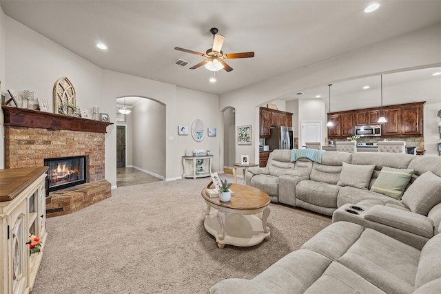 2725 Buffalo Run, Burleson, TX 76028 - living room with arched walkways, recessed lighting, light carpet, a ceiling fan, and a fireplace