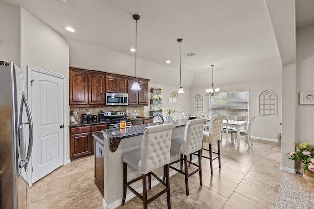 2725 Buffalo Run, Burleson, TX 76028 - kitchen with appliances with stainless steel finishes, a breakfast bar area, lofted ceiling, backsplash, and baseboards