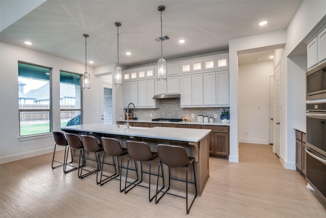 2309 Albion Way, Forney, TX 75126 - kitchen featuring stainless steel appliances, light wood finished floors, a kitchen bar, tasteful backsplash, and recessed lighting