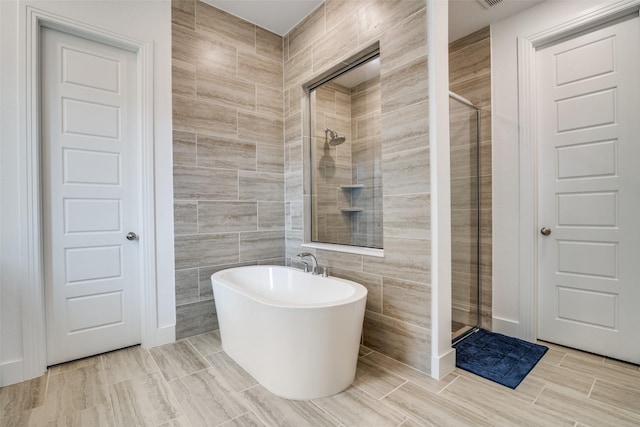 2309 Albion Way, Forney, TX 75126 - bathroom featuring a stall shower, a freestanding bath, and tile walls