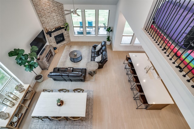 2309 Albion Way, Forney, TX 75126 - living area featuring wood finished floors, healthy amount of natural light, a brick fireplace, and a ceiling fan