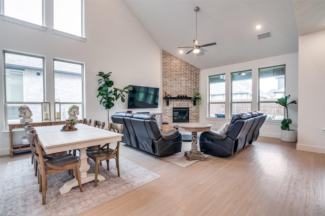 2309 Albion Way, Forney, TX 75126 - living room featuring ceiling fan, a brick fireplace, light wood-style floors, high vaulted ceiling, and baseboards