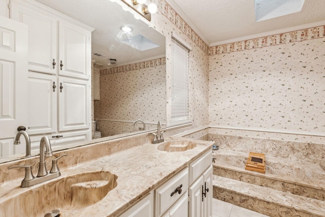 320 Conger Dr, Mesquite, TX 75149 - bathroom with double vanity, a textured ceiling, a bathtub, crown molding, and wallpapered walls