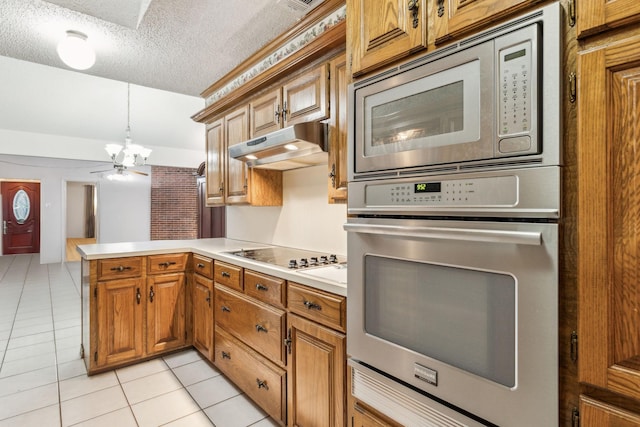 320 Conger Dr, Mesquite, TX 75149 - kitchen featuring stainless steel appliances, a chandelier, under cabinet range hood, a peninsula, and light countertops