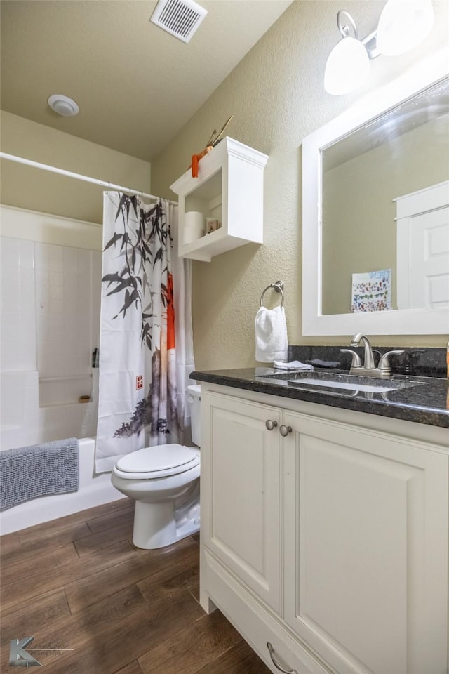 1001 Cabernet Dr, Abilene, TX 79601 - full bath featuring a textured wall, toilet, wood finished floors, vanity, and shower / tub combo with curtain