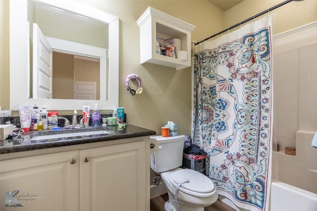 1001 Cabernet Dr, Abilene, TX 79601 - bathroom featuring a textured wall, toilet, vanity, and shower / bath combo with shower curtain