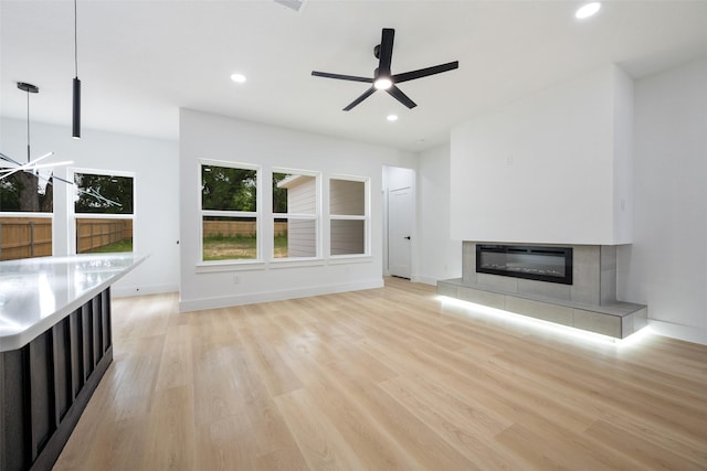 3900 De Maggio Ave, Dallas, TX 75210 - unfurnished living room featuring light wood-style flooring, recessed lighting, a tiled fireplace, and ceiling fan