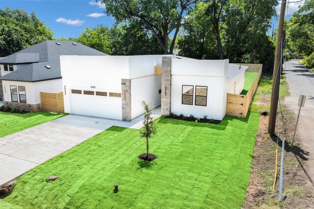3900 De Maggio Ave, Dallas, TX 75210 - contemporary house featuring a garage, roof with shingles, driveway, stucco siding, and stone siding