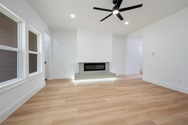 3900 De Maggio Ave, Dallas, TX 75210 - unfurnished living room featuring ceiling fan, a glass covered fireplace, recessed lighting, and light wood-type flooring